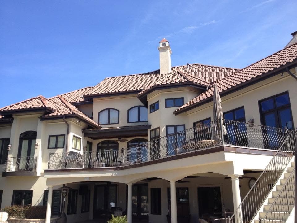 Mediterranean-style home with a terracotta tile roof, painted stucco walls and wrought-iron balconies.