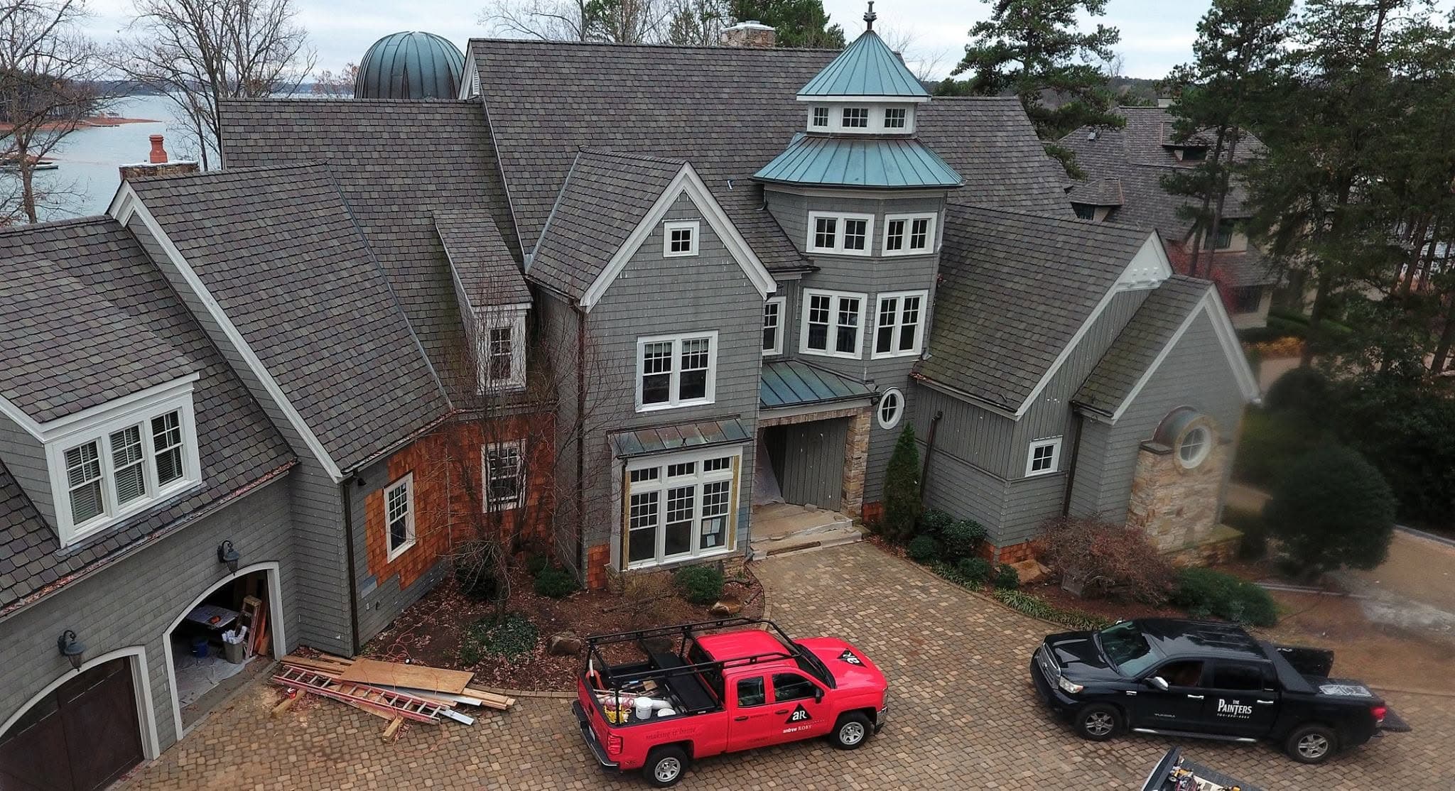 Elevated view of a large shingle-and-stone home with painted trim, typical of the homes we work on across the metro.