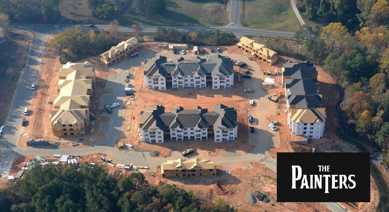 Aerial view of a housing development under construction, with multiple homes at various stages of completion.